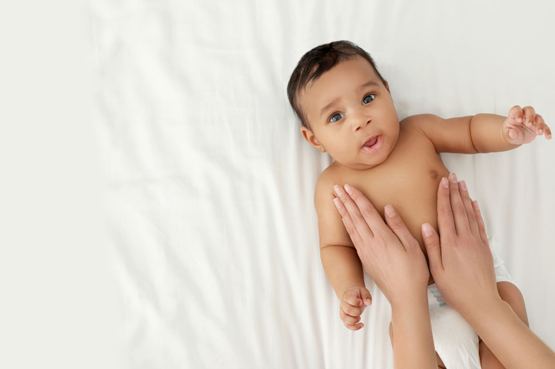 woman's hands comfort a happy baby