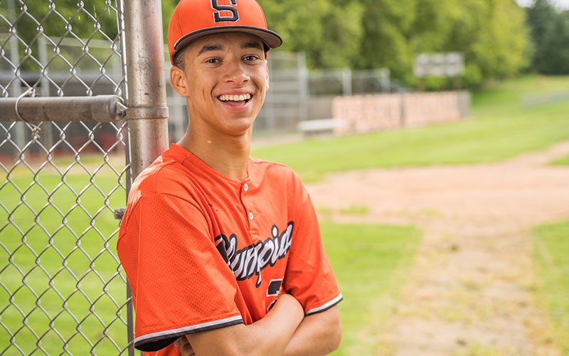 Teenager in Baseball Uniform Smiling