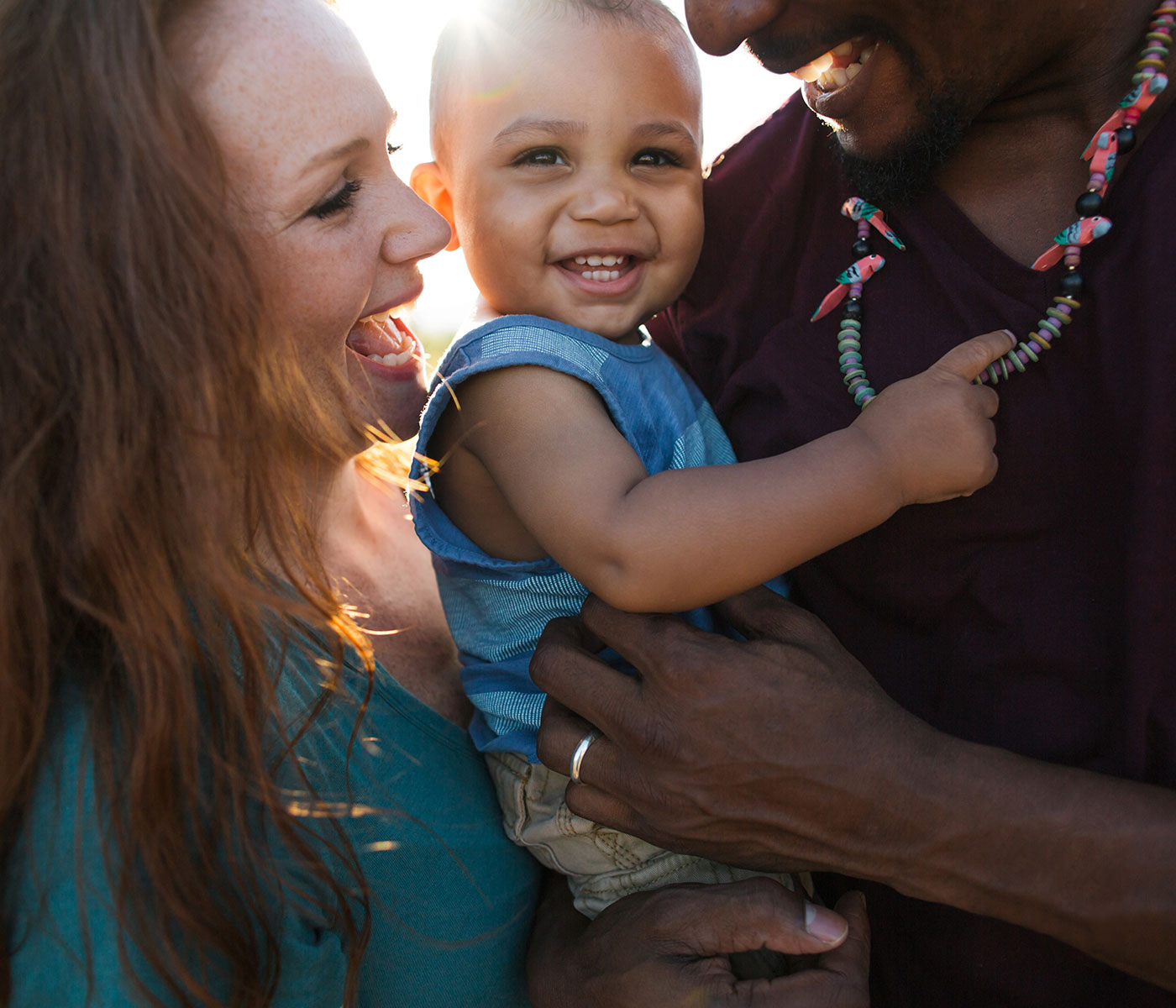 Mother, Father and Baby Smiling in Sunlight