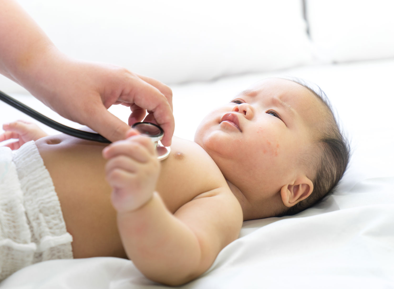 infant being checked with a stethoscope