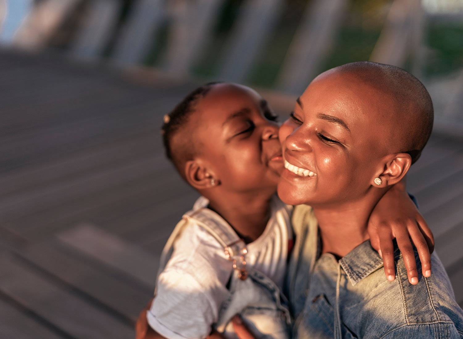 Young woman getting a kiss from her little girl