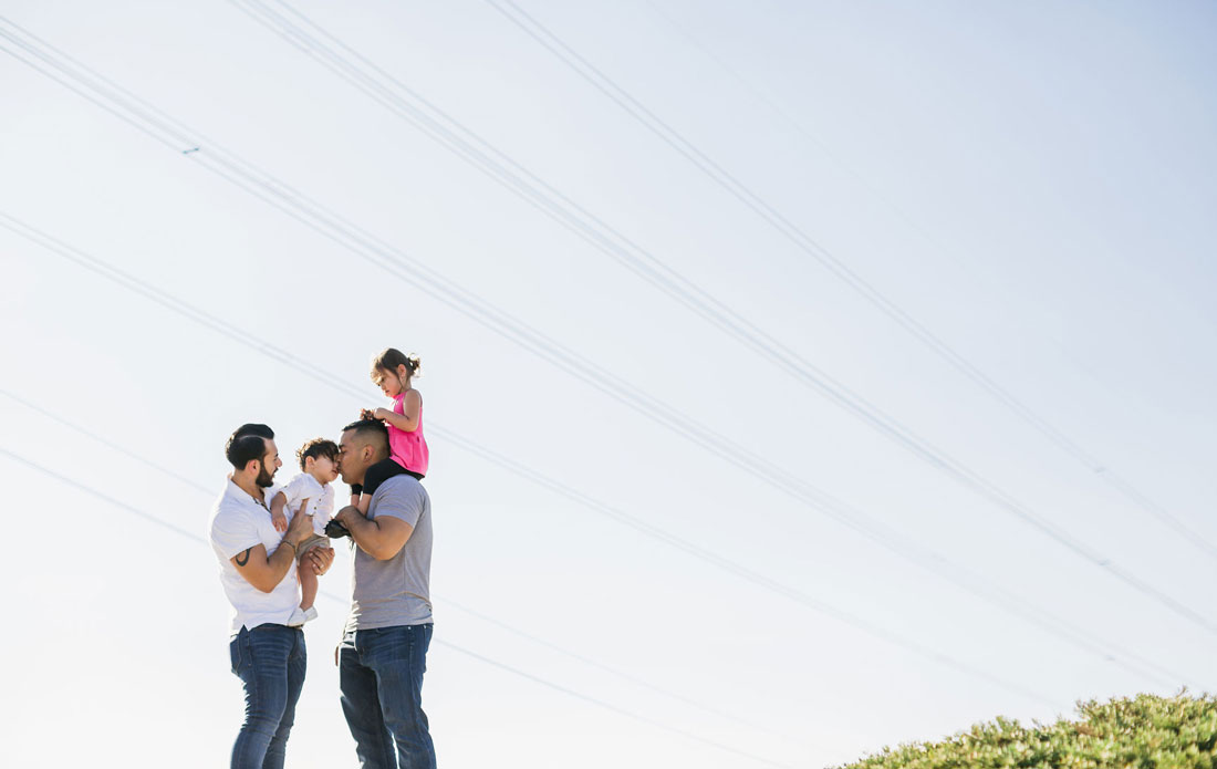 two dads with daughter and infant