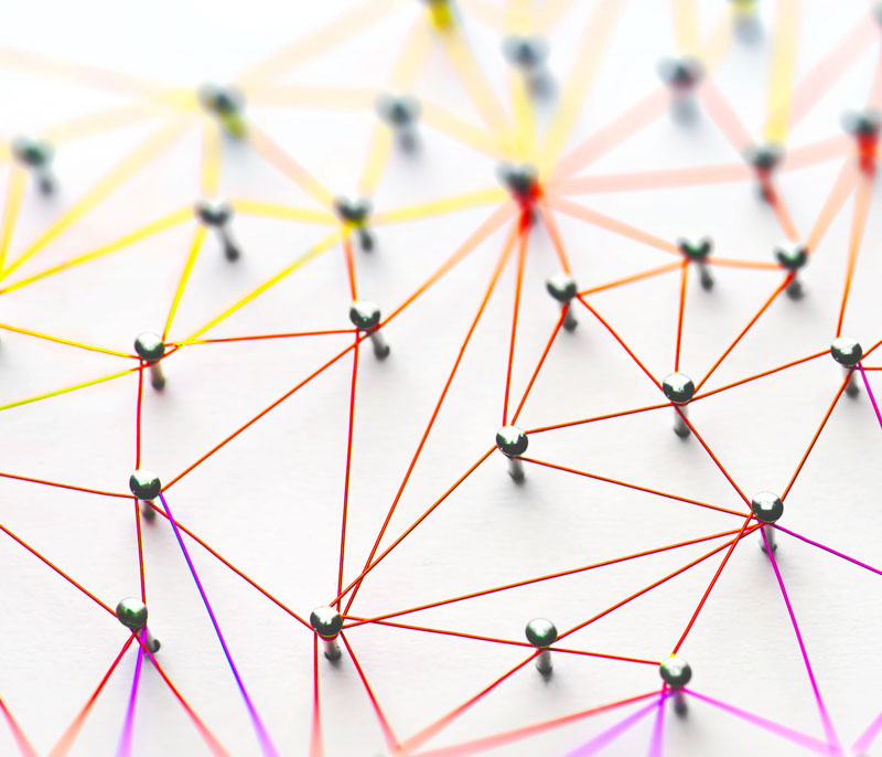 photo of a network of pins connected by yellow, orange and purple threads