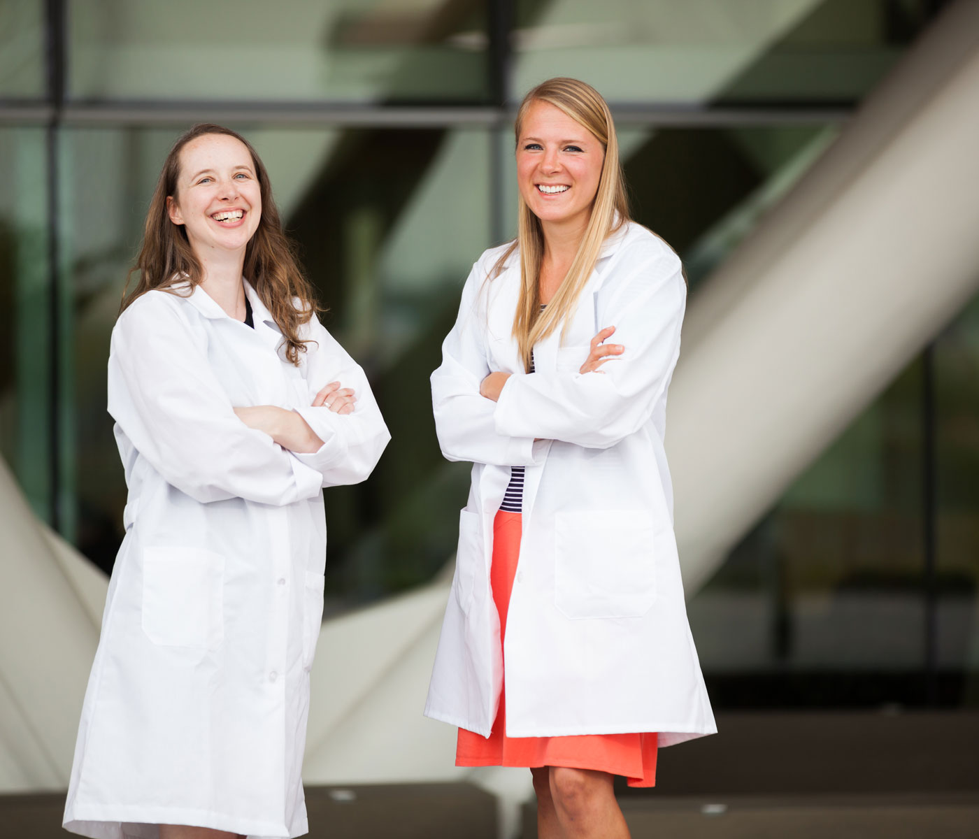 Two students in white coats outside the Robertson Life Sciences Building