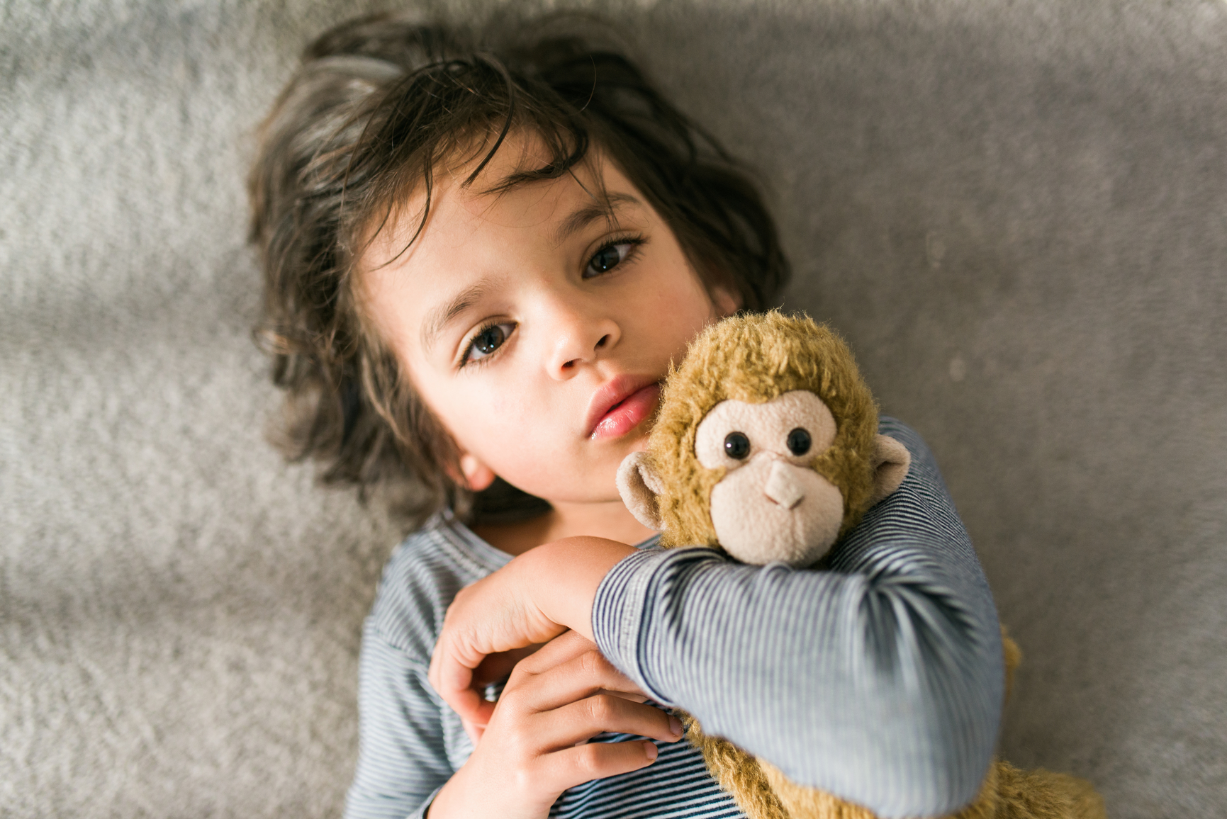 Young boy hugs stuffed animal