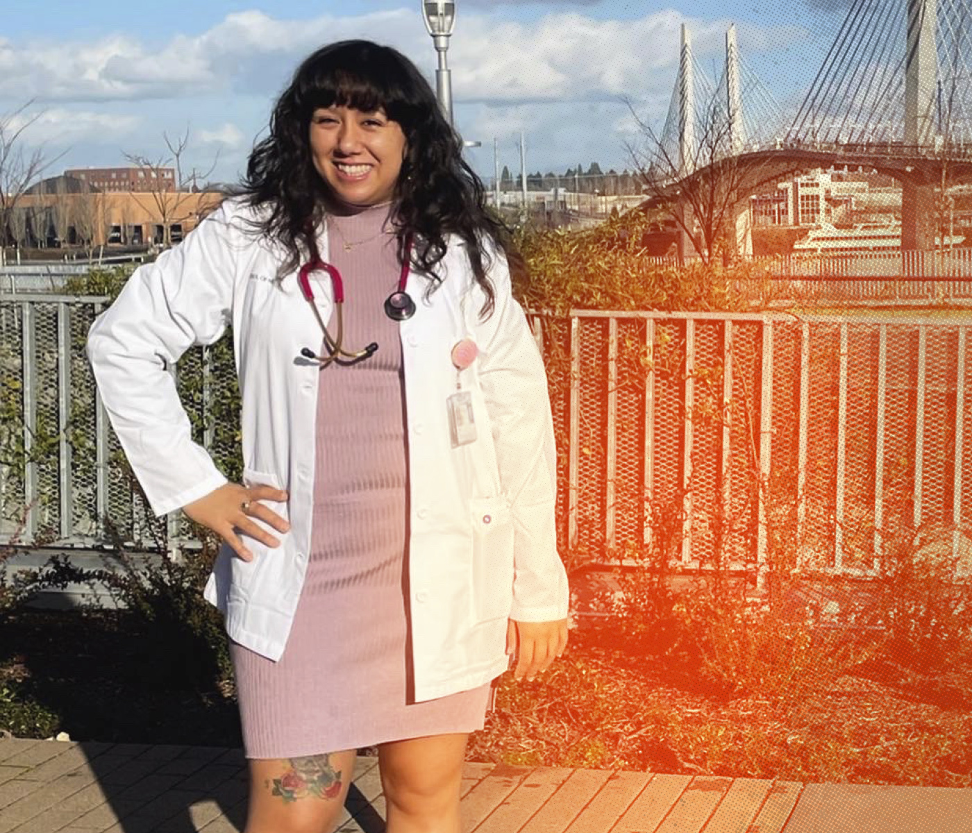 Medical student in her white coat stands by Tillicum Bridge