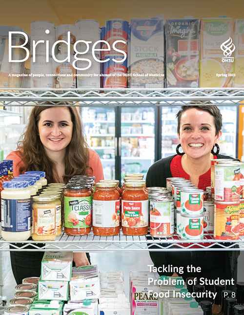 Two smiling young women standing behind a rack of canned food.