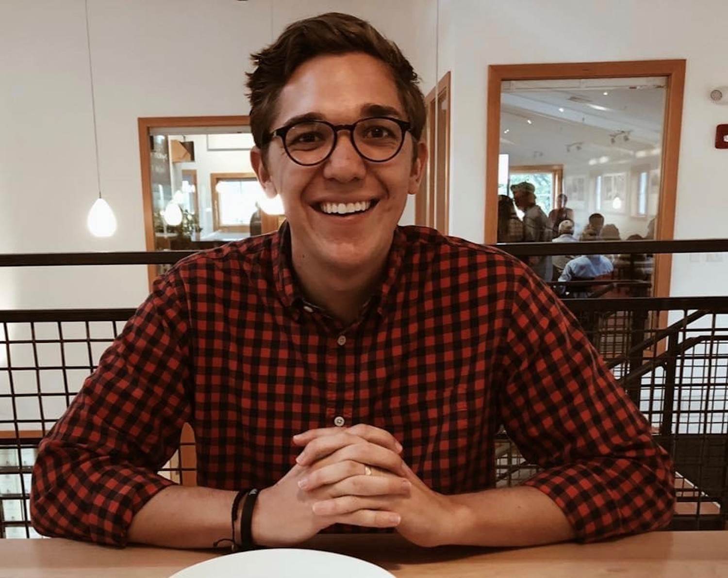 Headshot of employee, Hayden Rahn, wearing dark rimmed glasses and buffalo plaid shirt