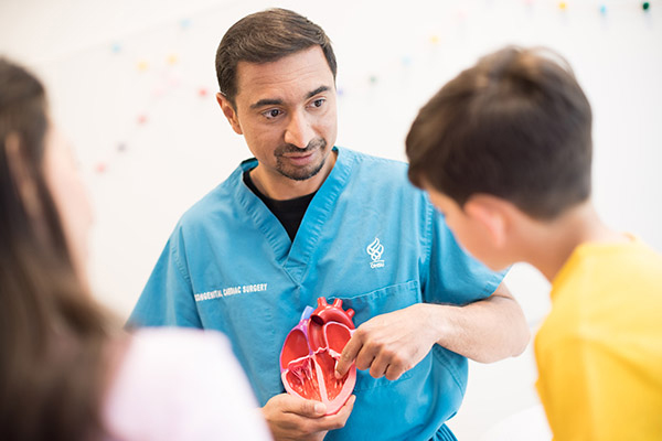 Ashok Muralidaran, M.D., shows a model of a heart to a patient.