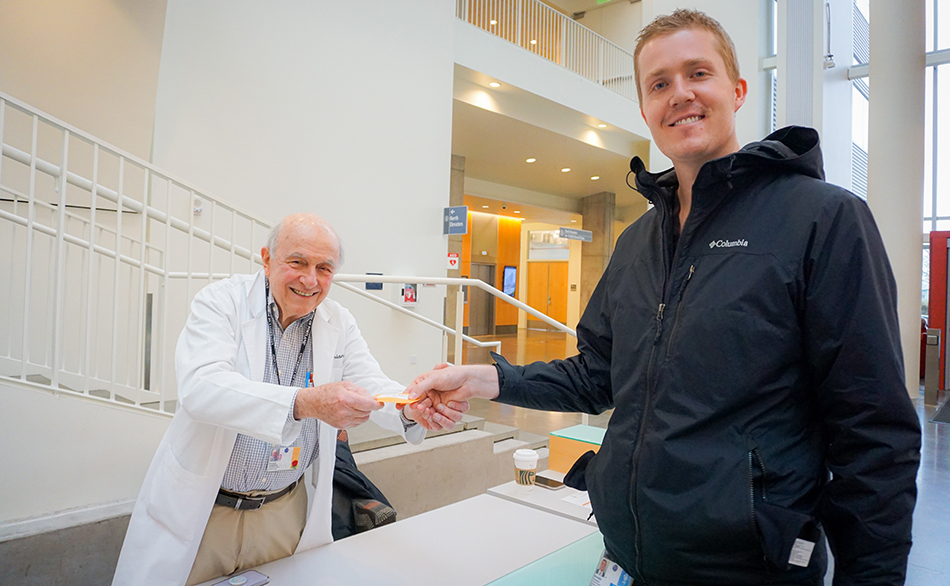 Don Sirianni hands a set of 3d printed teeth to OHSU dentistry student Brooks Hunsaker.