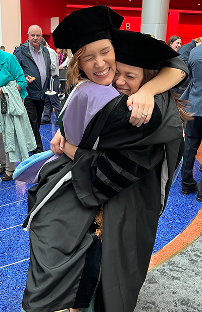Michelle Bloemers and Rachel Meek hugging after graduation