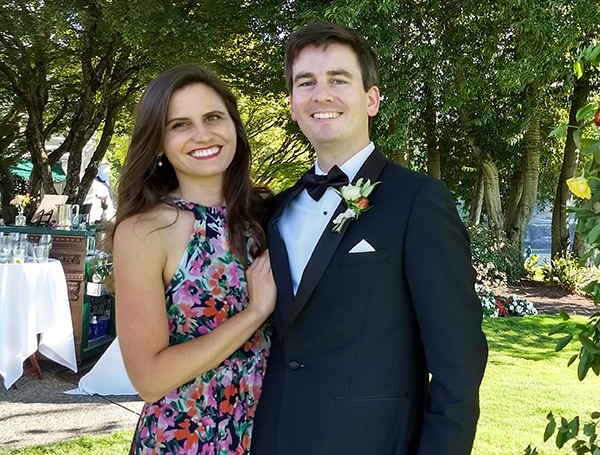 Joshua Lupton and wife Katherine Lupton posing in formal attire in front of some trees.
