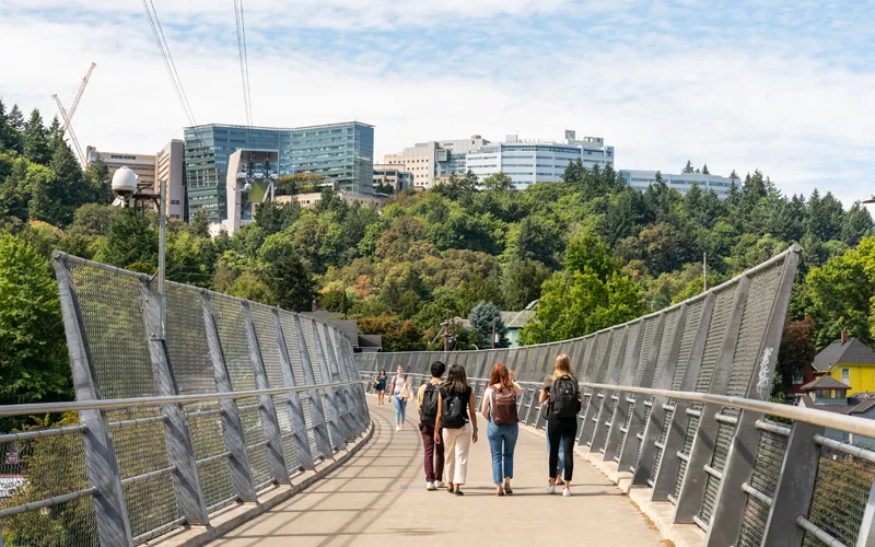 Students walking across pedestrian bridge toward OHSU Marquam Hill campus