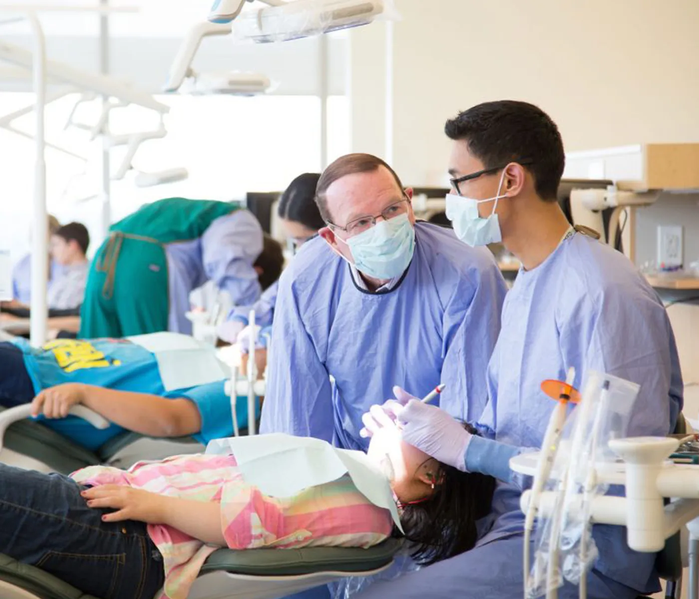 School of Dentistry student consults with faculty member while treating a young patient