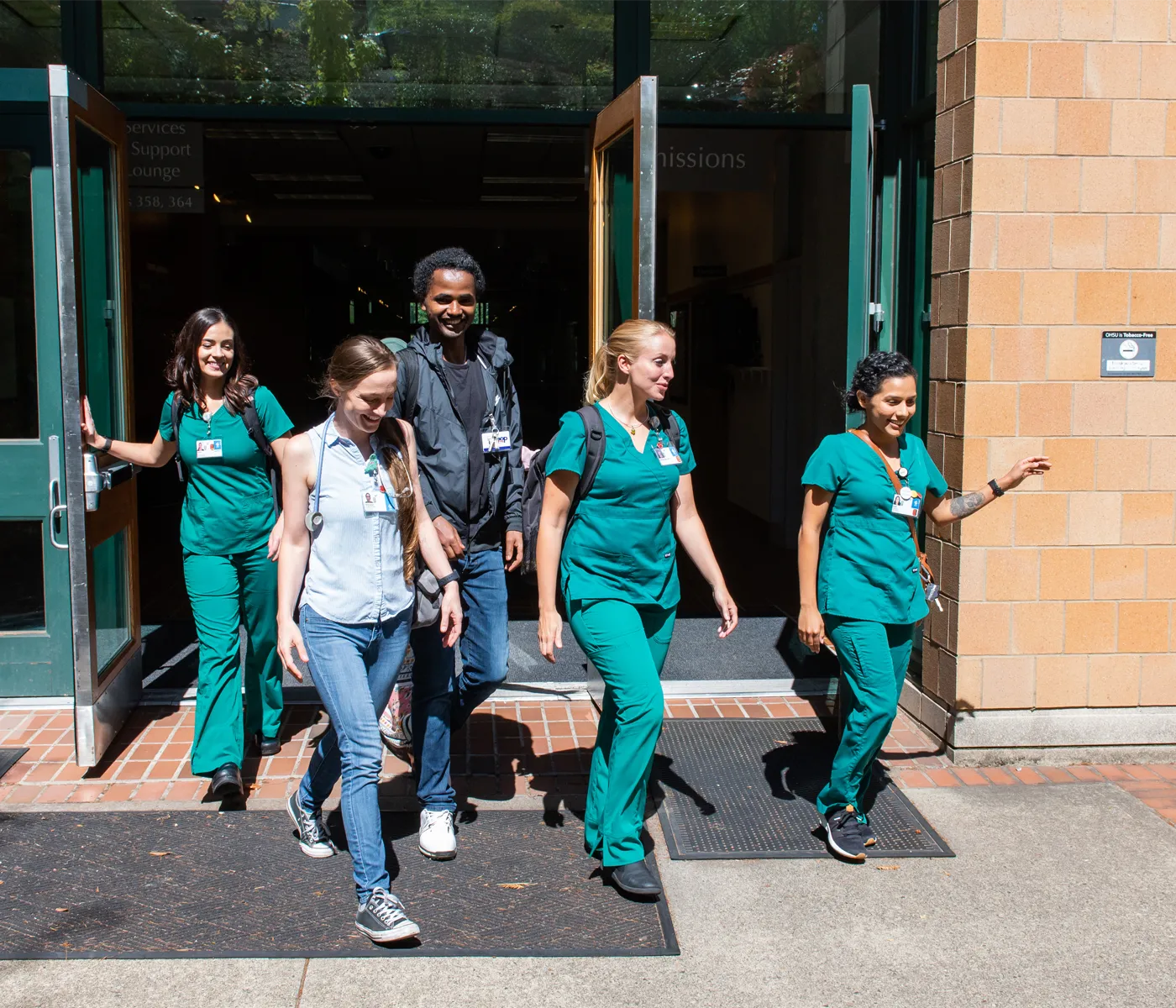 Four nursing students walking out of the school of nursing building