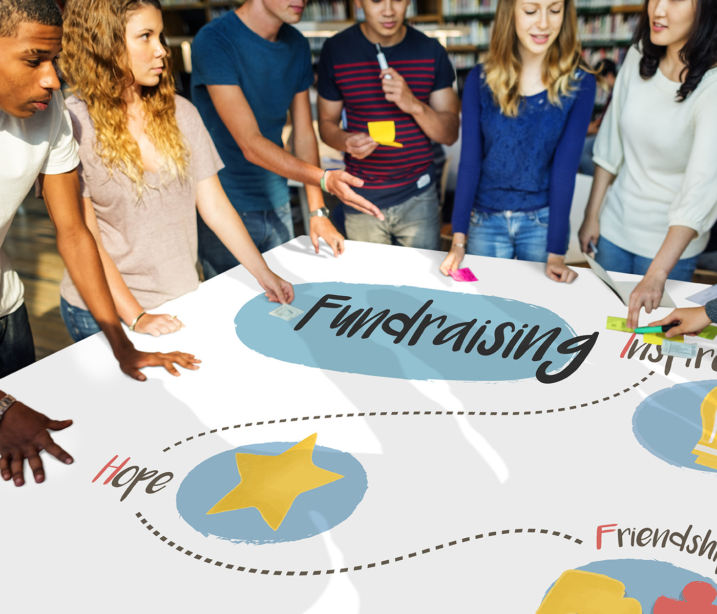 high school students in a classroom stand around a banner about fundraising