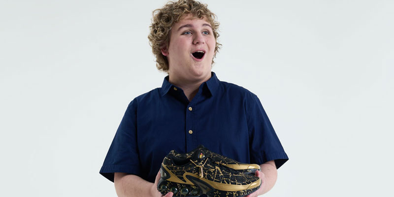 Connor holds the shoes he designed for Doernbecher Freestyle 20