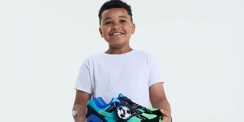 Ja'Kai holds the Doernbecher Freestyle shoes he designed for Freestyle 20