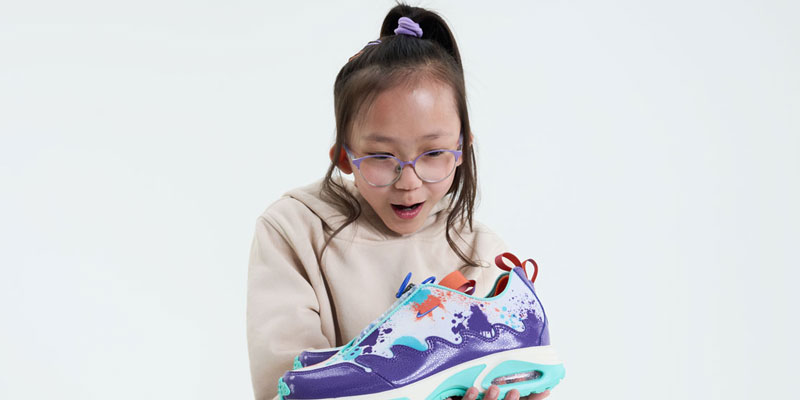 Quin holds the shoes she designed for Doernbecher Freestyle 20