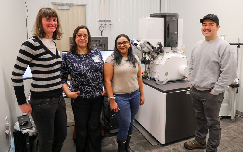 Claudia Lopez and her lab team stand among powerful microscopes
