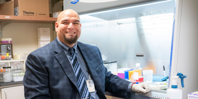 Neuroradiologist Ramon Barajas, Jr., M.D., wears a suit and tie in his lab