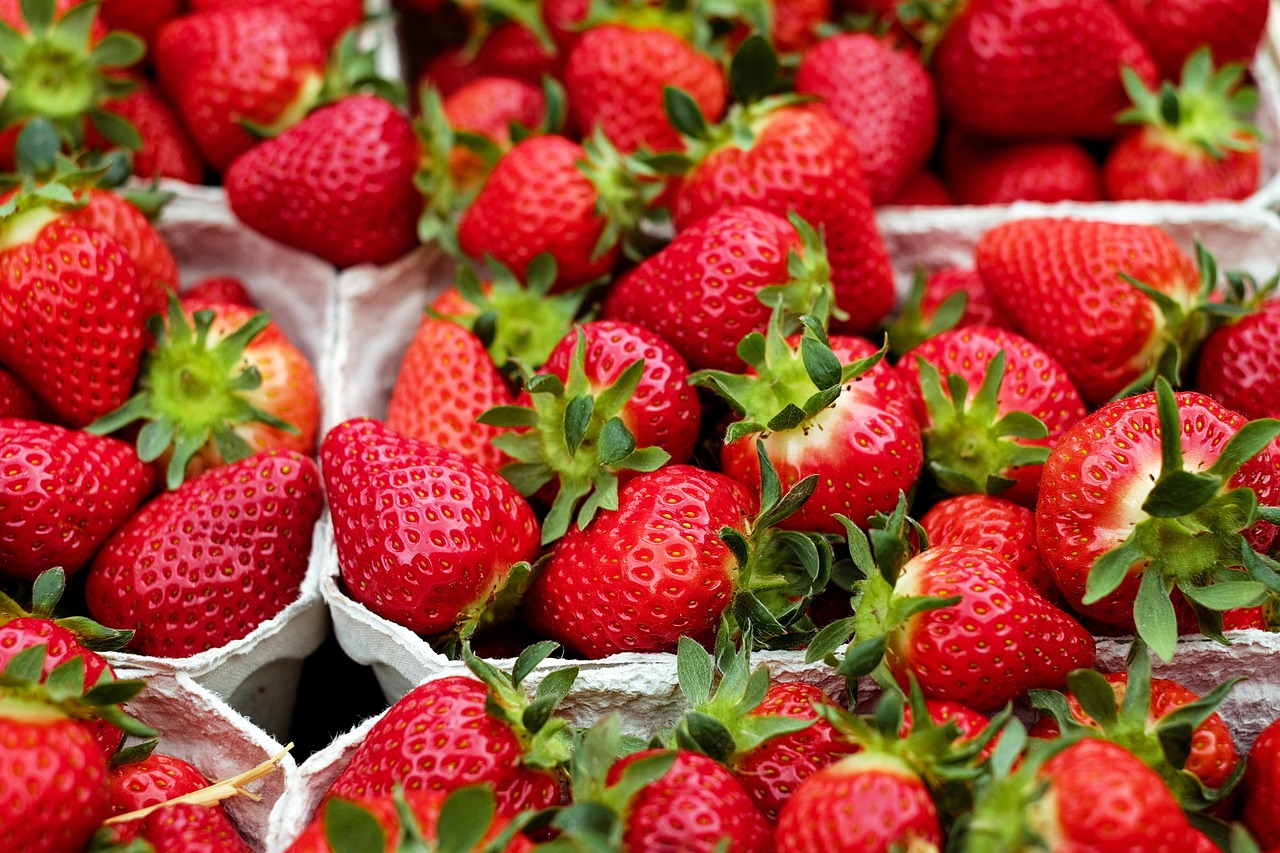 A close-up image of strawberries in cartons side-by-side filling the frame.