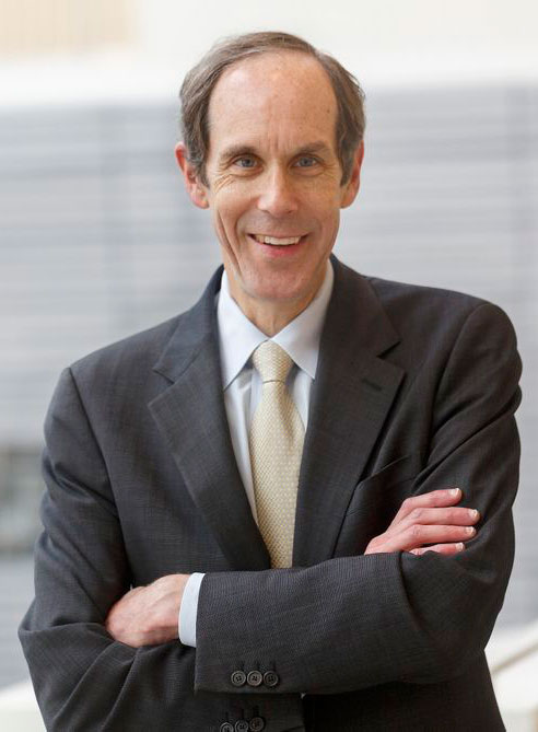 Brian Druker stands outside with his arms crossed