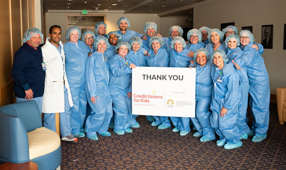 Credit Unions for Kids Advisory Group wears scrubs to tour the hybrid OR