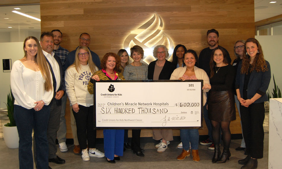 People standing around a giant check