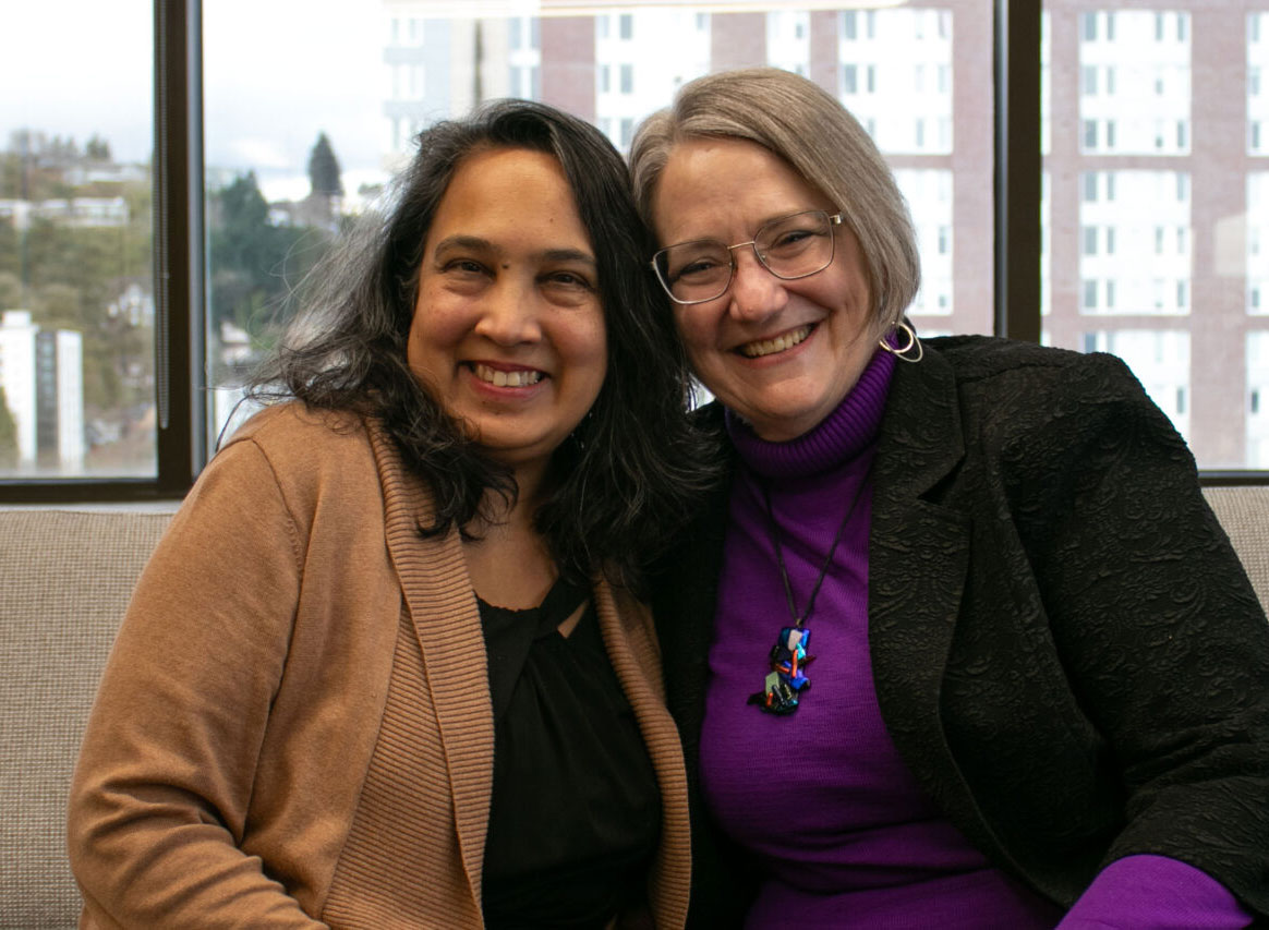 Two longtime friends - a doctor and her patient - lean in close and smile for the camera