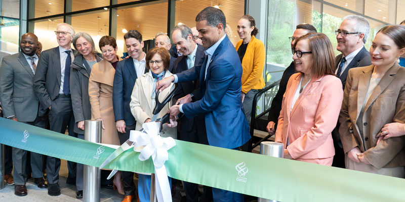 Business and government leaders surround OHSU President Shareef Elnahal as he cuts the ribbon for the Vista Pavilion ceremony.
