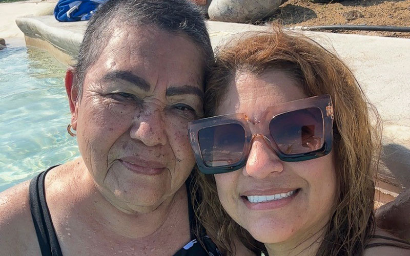 A woman and her daughter pose for a photo in a swimming pool