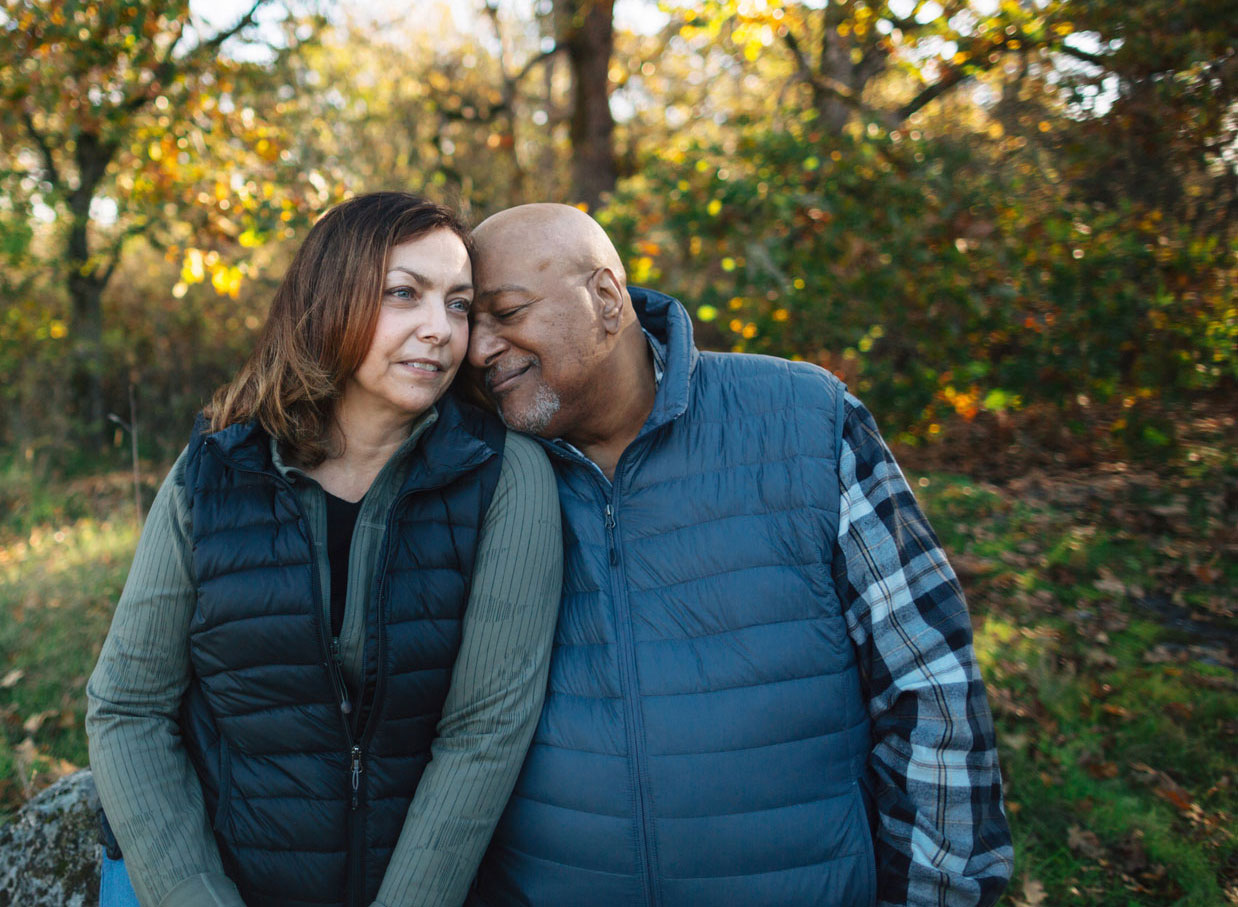 A couple dressed in outdoor gear lean in close to each other