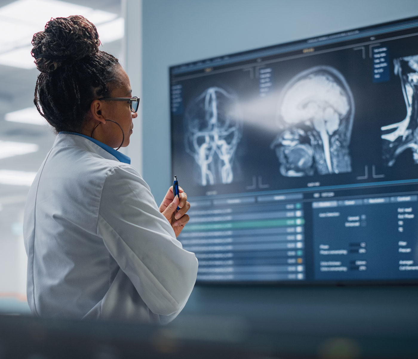 Doctor looking at brain scans on a big monitor