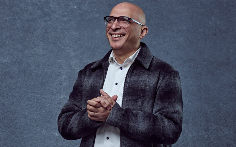 Ahmed Raslan wears a plaid jacket, a white dress shirt and glasses.